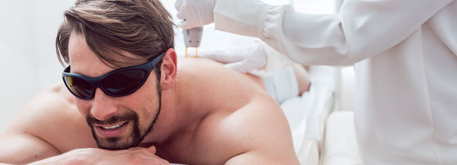 Laserbehandlung am Rücken, Kunde mit Schutzbrille
